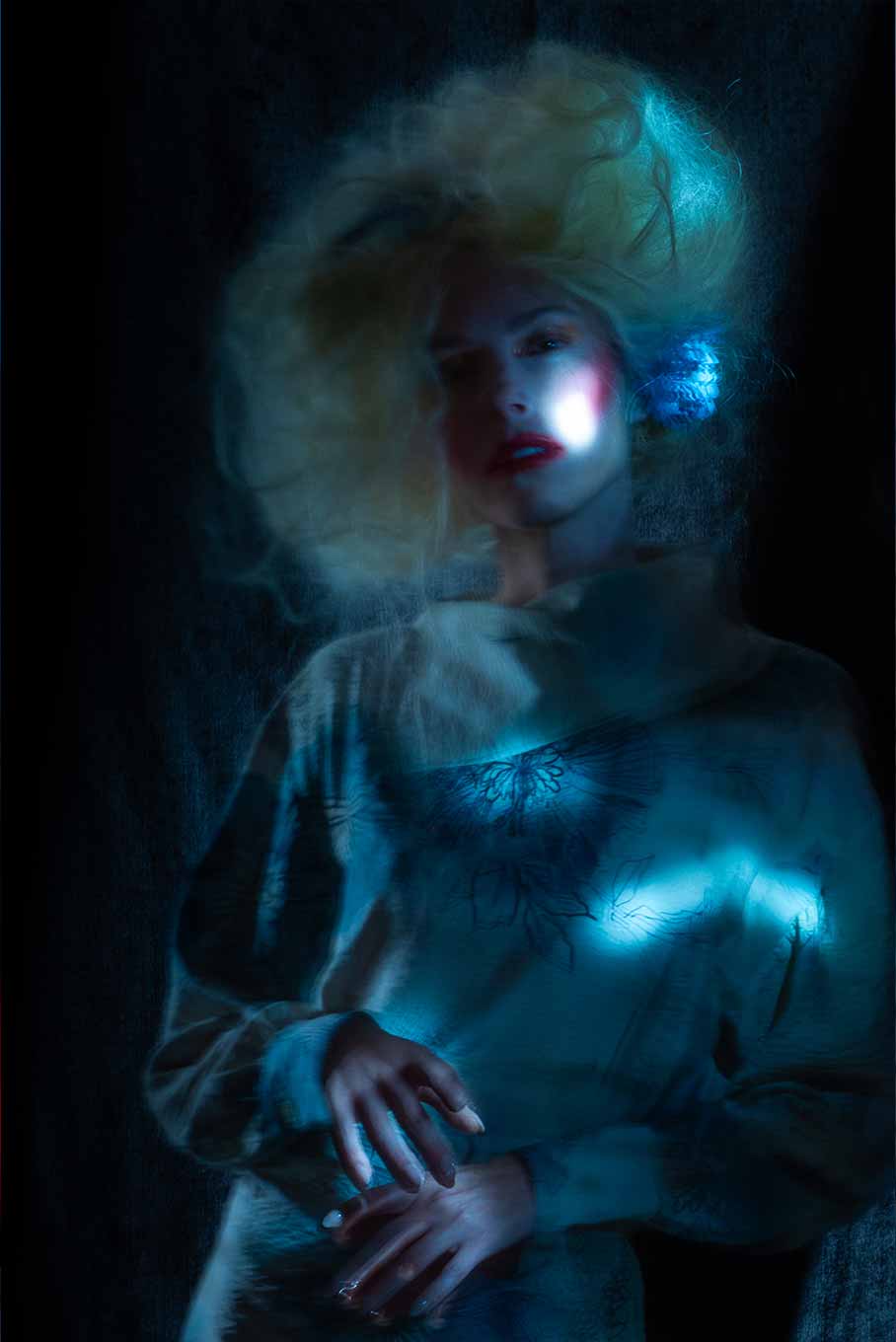 Medium shot of a model photographed with long exposure and dynamic lighting, creating flowing light trails around the figure.